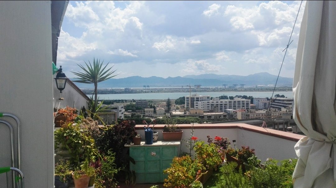 The view from a rooftop terrace over Cagliari’s lagoon and mountains