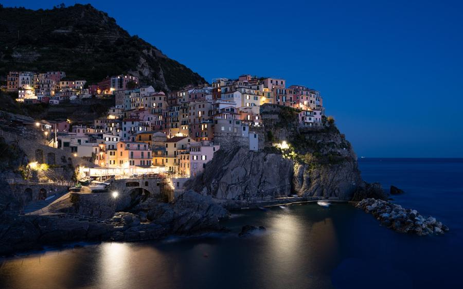 Cinque Terre: the postcard view of Manarola at blue hour, as the lights come on.