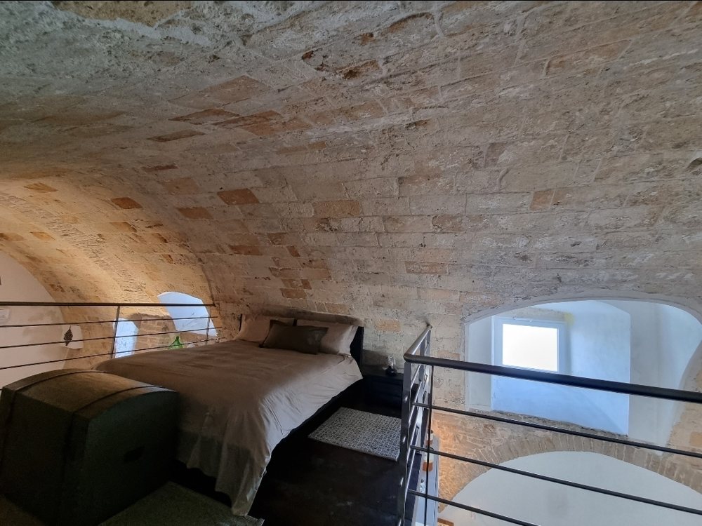 A bedroom under a stone vault in Molfetta’s old town