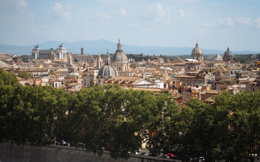 Rome: domes and rooftops from above, with the mountains behind.