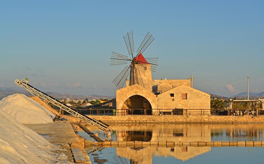 Trapani: the salt flats and an old windmill in golden evening light.