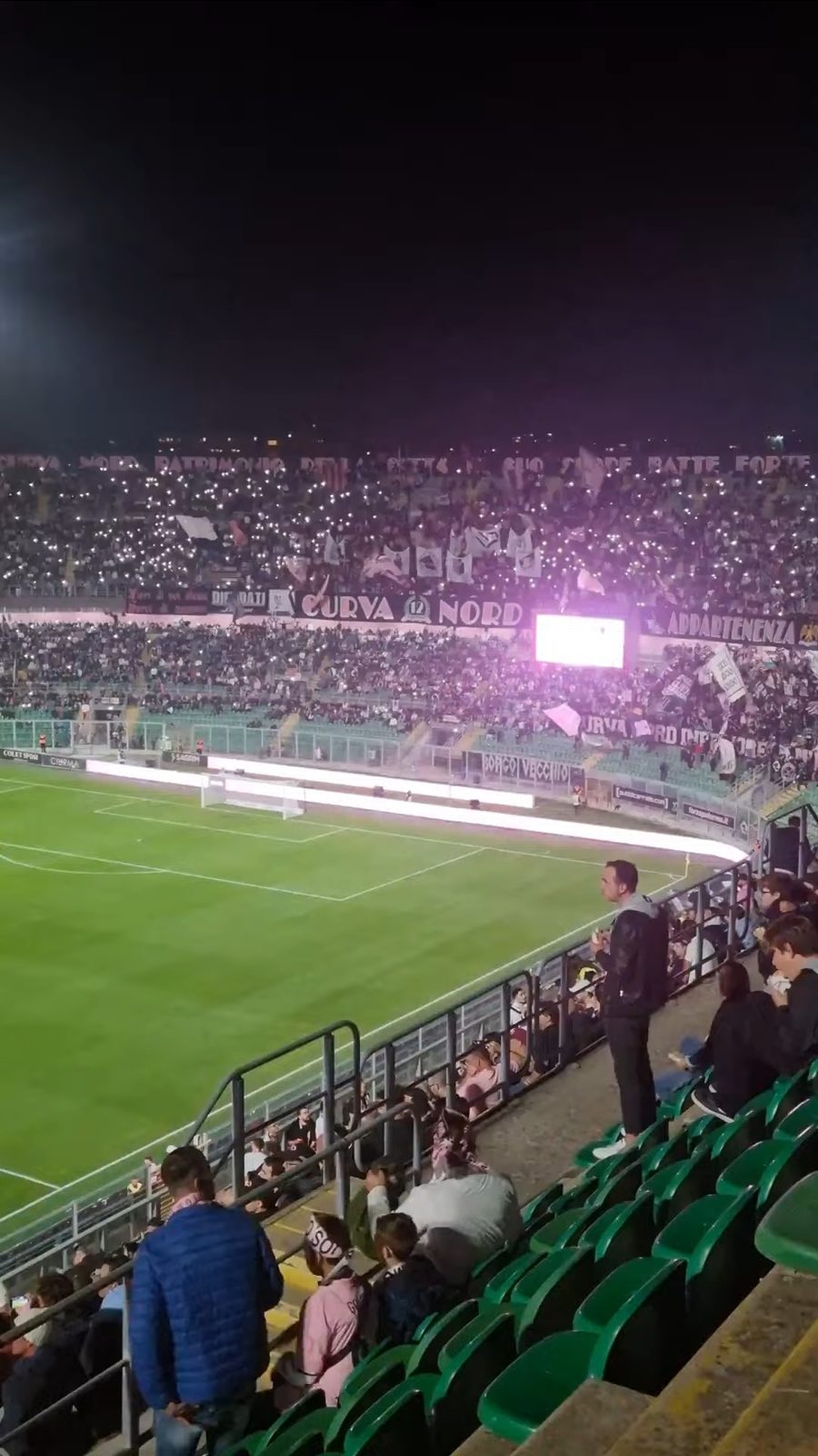 Phone lights across the Curva Nord, seen from the upper stand